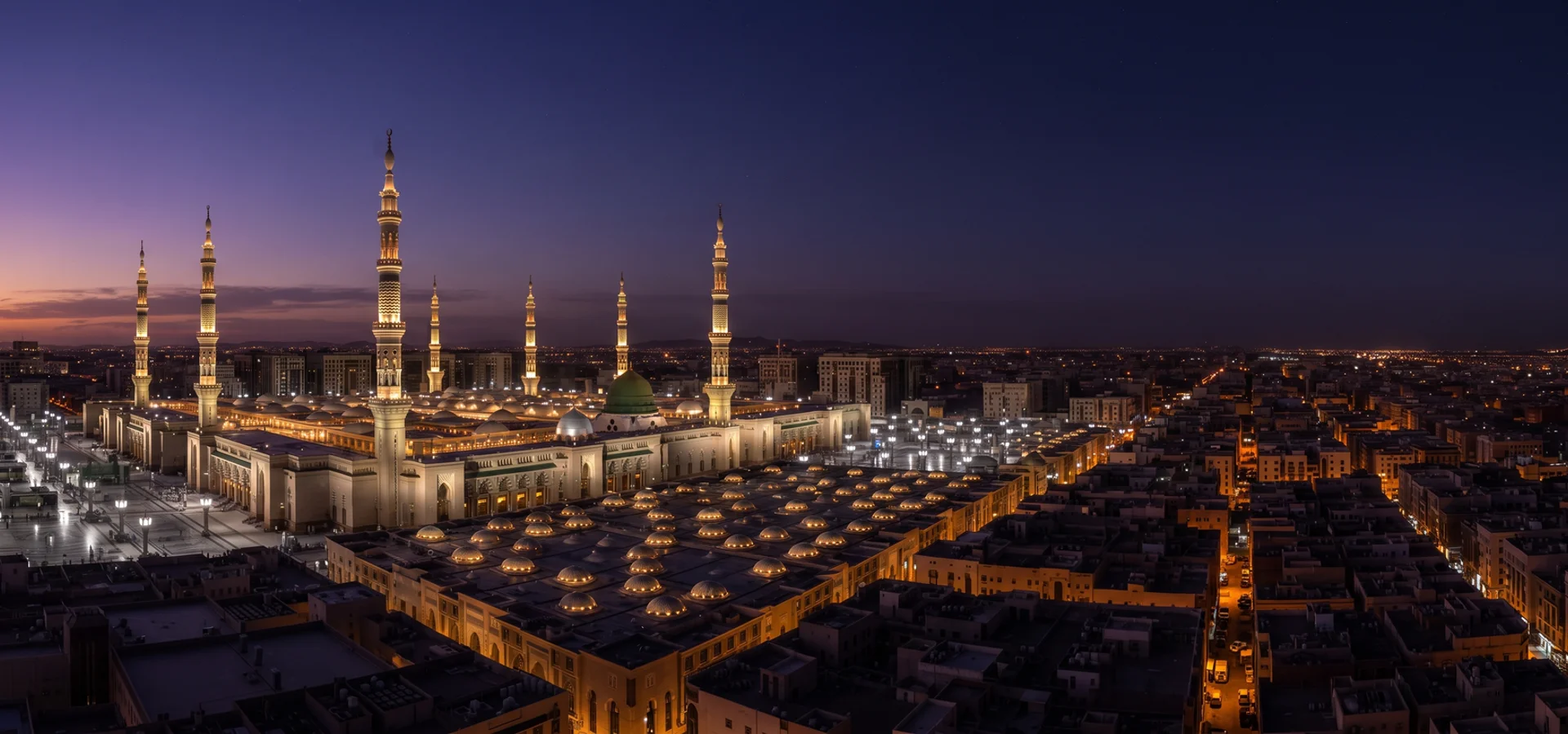 Aerial dusk view of Madinah with glowing minarets