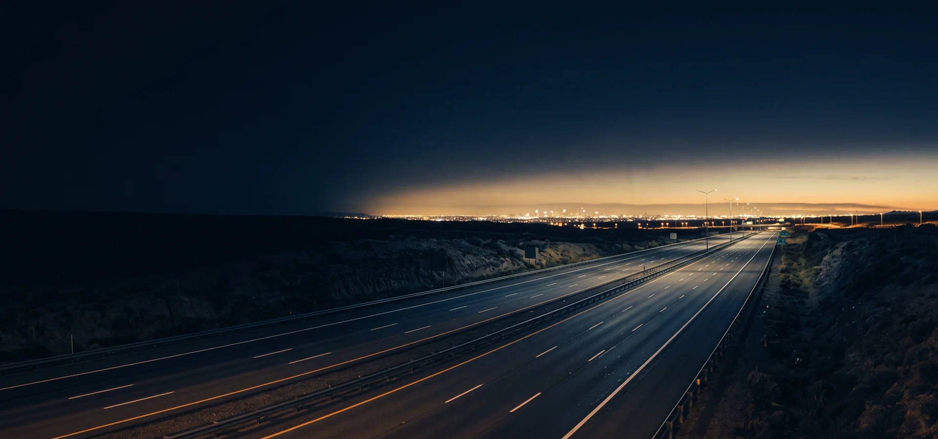 Night highway leading toward distant city lights