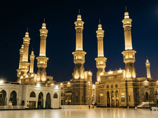 Haram minarets against a deep indigo night sky