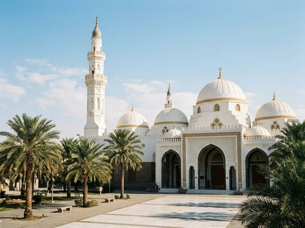 Quba Mosque exterior in bright winter daylight with white domes and palms