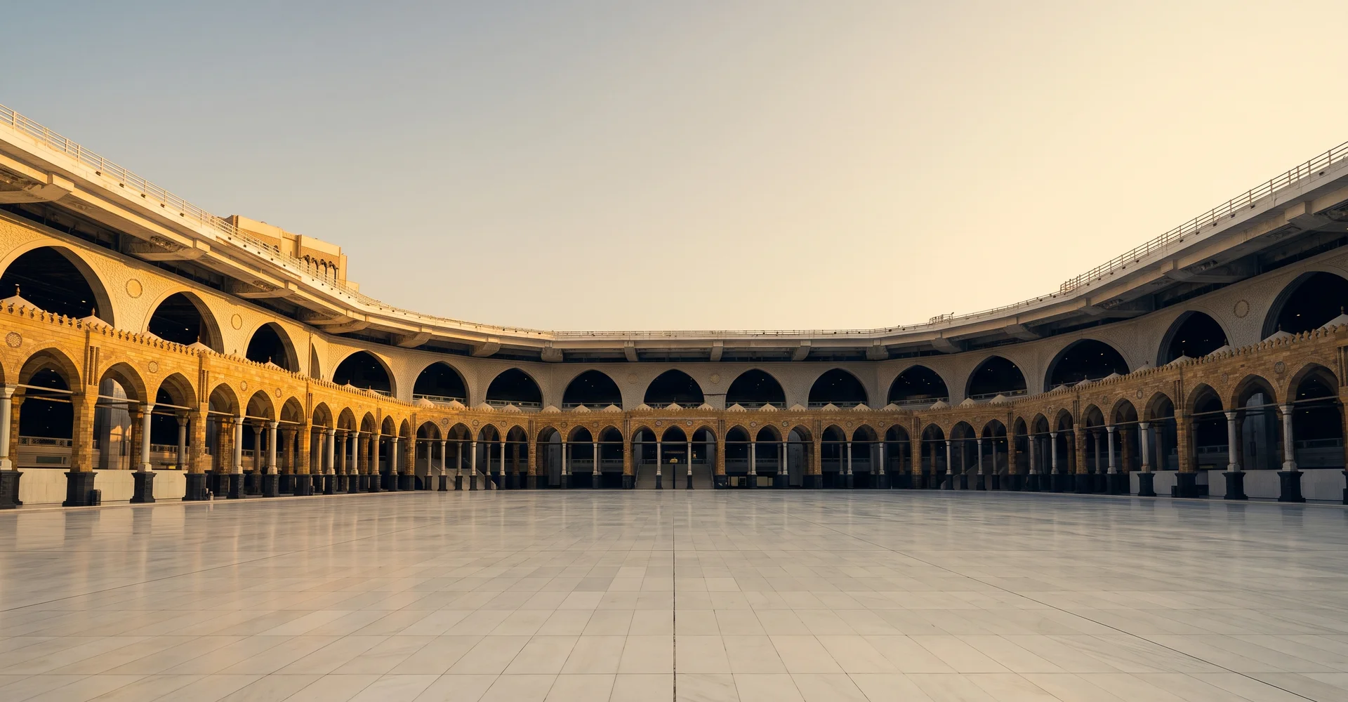 Marble courtyard and colonnade of the Masjid al-Haram in warm golden light